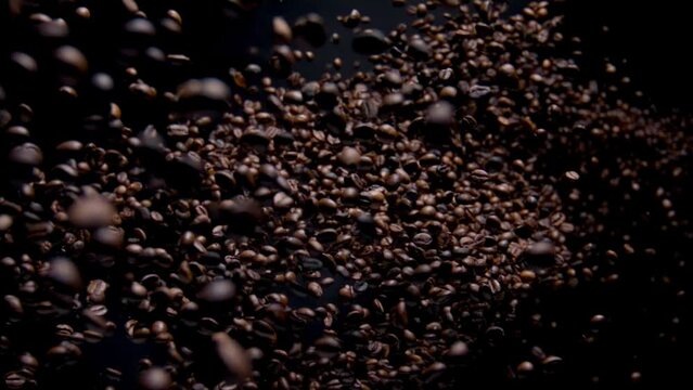 Exploding aromatic coffee grains in super slow motion. Roasted seeds falling.