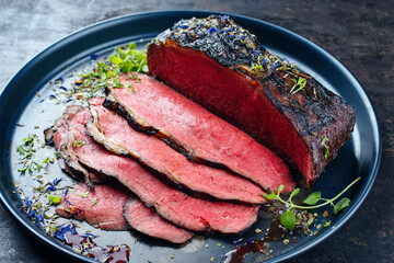 Traditional Commonwealth Sunday roast as sliced cold cuts roast beef with herbs and spice as...