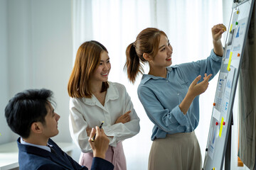 group of professional Asian businessmen use paper on the board. Writing a business plan strategy for growth and success Happy Asian woman working at the office
