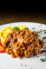 Fried liver with onion and mashed potatoes on white plate