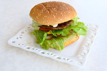 Big tasty burger with beef cutlet on a plate. Crispy chicken burger.
