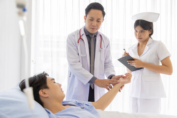 Obraz premium Professional doctor and nurse visiting checking recover male patient at hospital