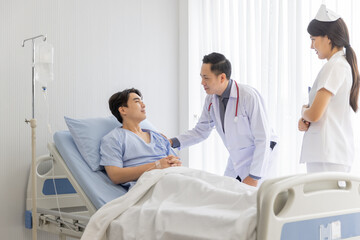 Obraz premium Professional male doctor and nurse caring visiting encourage male patient at hospital