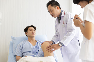 Obraz premium Professional orthopaedist male doctor and nurse visiting checking examine knee condition male patient at hospital