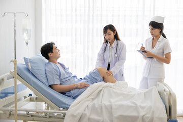 Professional orthopaedist female doctor and nurse visiting checking examine knee condition male patient at hospital