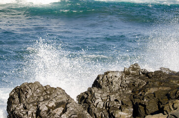 Splash of a wave breaking against the rocks of the coast. Quintanilla. Arucas. Gran Canaria. Canary Islands. Spain.