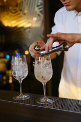 the bartender prepares two cocktails