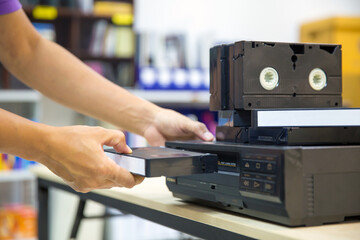 Fototapeta premium Close-up hand putt playback button on video record player concept of retro style or vintage electric and electronic appliances multimedia playback device old fashioned.