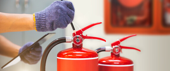 Fire extinguisher has hand engineer inspection checking pressure gauges to prepare fire equipment...