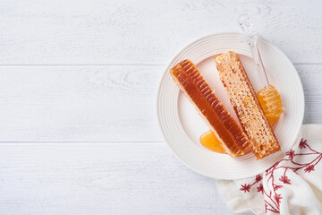 Rosh Hashanah. Honey jar, honeycomb, apple and pomegranate on white wooden old rustic background table. Jewish New Year holiday greeting card. Rosh Hashanah holiday attributes. Space for text