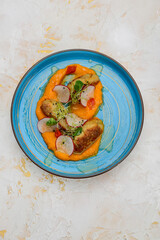 chicken cutlets on a pumpkin pillow with radish in a blue plate
