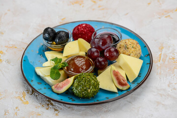 canned fruits and berries with cheese in a blue plate
