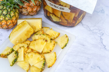 sliced pineapple on cutting board preparing to make  home-brew Tepache fermented beverage made from pineapple.