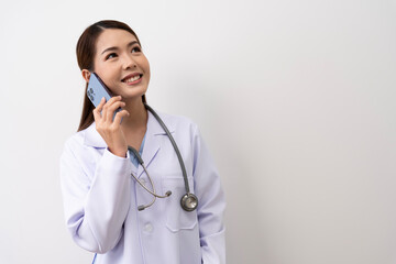 An Asian female doctor in Thailand is communicating with patients over the Internet with her personal phone at the hospital to advise patients at home with confidence isolated background