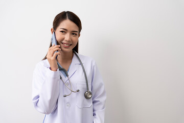 An Asian female doctor in Thailand is communicating with patients over the Internet with her personal phone at the hospital to advise patients at home with confidence isolated background