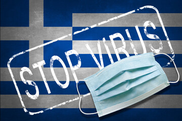 Lettering stamp Stop Virus and medical mask on Greece flag. Return of the coronavirus. New jump in...
