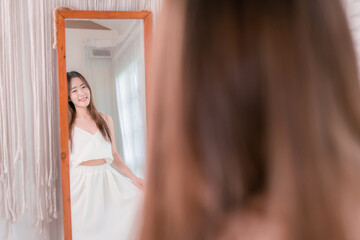 Asian woman choosing clothes dress-up mirror at home fashion lifestyle, Shopping concept.