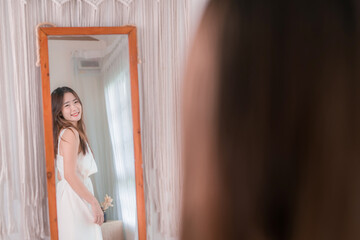 Asian woman choosing clothes dress-up mirror at home fashion lifestyle, Shopping concept.