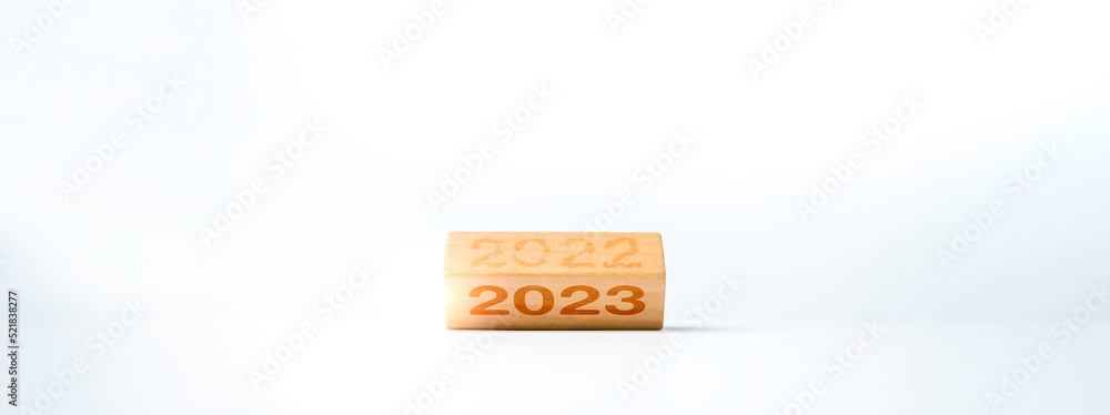 Poster 2023 happy new year concept banner. flipping the 2022 to 2023 year numbers calendar on wooden cube b