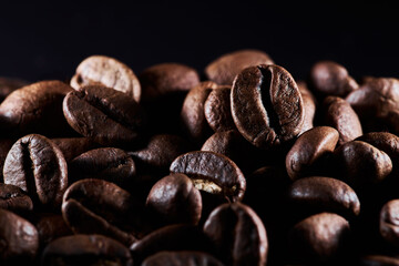 Roasted coffee beans isolated close up on black background, clipping path