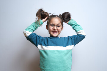Fototapeta premium Portrait of funny brunette little girl fooling around rejoicing isolated on white background