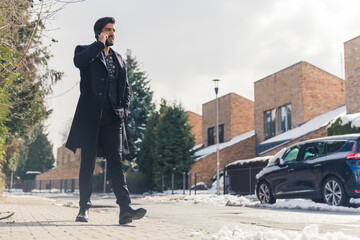 Businessman wearing suit and coat walking around neighbourhood on winter morning making business...