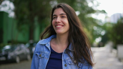 One happy woman walking forward outside. A confident person walks smiling