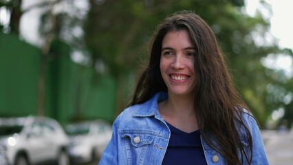 Happy young woman walking outside. A joyful expressive girl smiling going for a walk being carefree