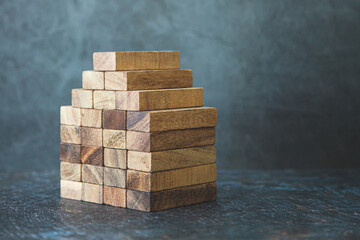 Wooden block stack in pyramid concept of prevent collapse or crash of financial business and risk...