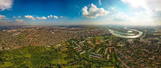 low-rise buildings in the western part of the city of Krasnodar near the Agrarian University. The Kuban River on the horizon. Aerial panorama on a sunny summer day - obrazy, fototapety, plakaty