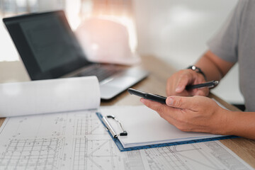 Engineering work concept, Engineer a calculator to calculate and plot engineering work from a drawing and laptop in work office