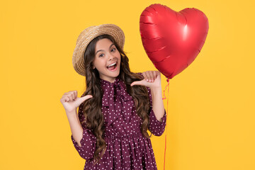 amazed teen girl with red heart balloon on yellow background. point fingers on herself