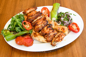 A skewered chicken kebob with grilled onions, bell peppers and delicious white meat with seasoning isolated on a white background. Tavuk sis, Tavuk izgara.