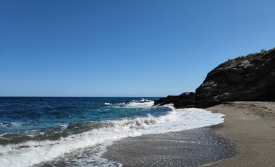 beautiful rocky beach summer fun dynamic waves breaking blue sky sunshine and a lonely beach