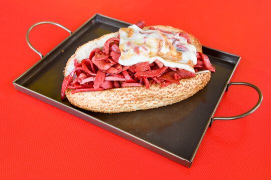 Close-up shot of Izmir's famous Turkish Traditional Kumru Sandwich, &Ccedil;eşme Kumru, Karisik sandvic,  ingredients ready to eat salami, soudjouk, tomato, cheddar cheese and fried cheese. Yengen sandvic.