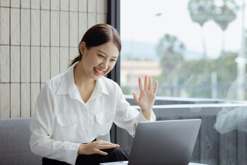 Asian businesswoman looking at laptop screen and remote video call with startup partner, she talks...