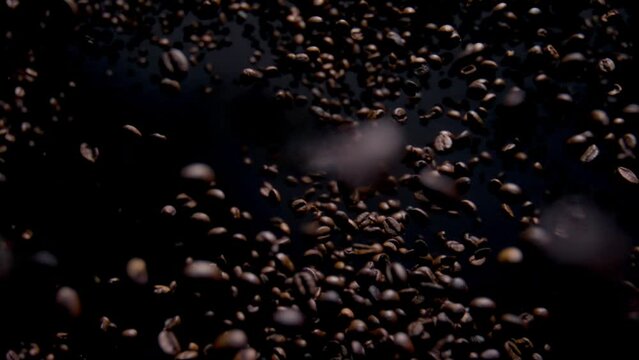 Magic view falling coffee beans on dark background. Aromatic seeds downfall.