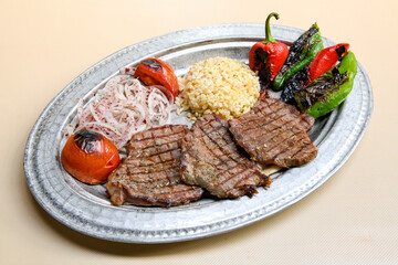 Beef steak grill with rice pilaf, fried potatoes, grilled pepper and tomatoes.Mix Platter with Beef rips, Cutlets, Potatoes and Sauces.