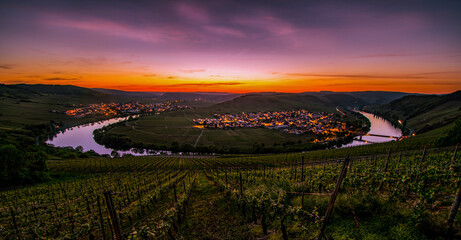 Far view over Mosel loop with vineyards in foreground during spectacular colorful sunset near Leiwen, Germany