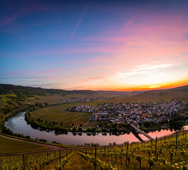 Far view over Mosel loop with vineyards in foreground during spectacular colorful sunset near Leiwen, Germany