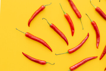 Flat lay dried red chili peppers pattern on a yellow color background. Top view, flat lay.