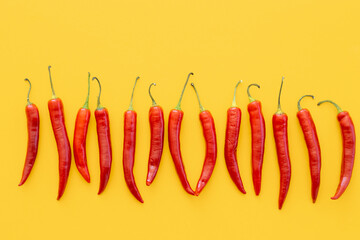 Flat lay dried red chili peppers pattern on a yellow color background. Top view, flat lay.