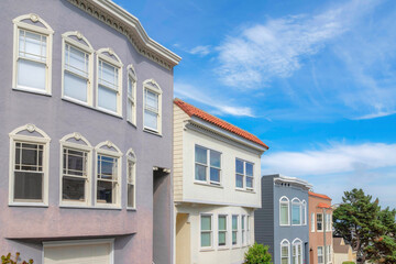 Facade of townhouses with purple, white, and gray exterior in a sloped land in San Francisco, CA