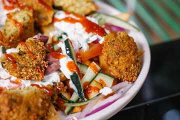 Platillo griego con falafel, pepino, cebolla morada y tzatziki 