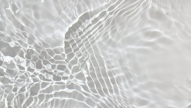 Pure water with reflections sunlight in slow motion. Water surface texture top view. Sun and shadows. Motion clean swimming pool ripples and wave. High quality 4k footage