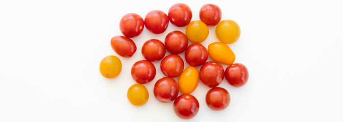 Yellow and red cherry tomatoes on white background