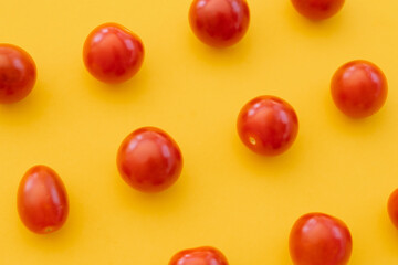 Fresh cherry tomatoes on yellow background