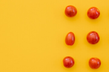 Fresh cherry tomatoes on yellow background