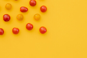 Fresh cherry tomatoes on yellow background