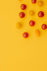 Fresh cherry tomatoes on yellow background